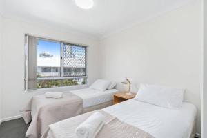 2 camas en una habitación con ventana en Bay Lodge - Private Apartments, en Gold Coast