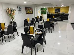 uma sala de jantar com mesas e cadeiras num restaurante em Hotel Business Center em Popayán