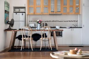 a kitchen with a wooden table and two chairs at Gables Bend Spa Villa in Daylesford