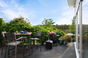 a patio with chairs and a table on a balcony at Gables Bend Spa Villa in Daylesford
