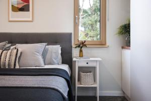 1 dormitorio con 1 cama y mesita de noche junto a una ventana en Green Retreat Passive House, en Hepburn Springs