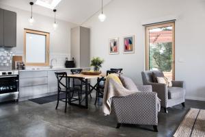 cocina y sala de estar con mesa y sillas en Green Retreat Passive House, en Hepburn Springs