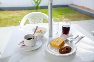 a table with a plate of cake and a cup of coffee at Solare Hotel in Barcarena
