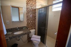 a bathroom with a toilet and a sink and a shower at Solare Hotel in Barcarena