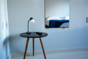 una mesa con una lámpara en una habitación en Solare Hotel, en Barcarena