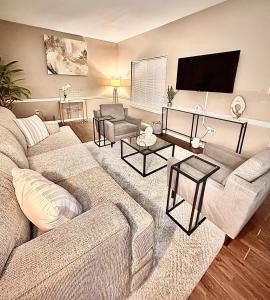 a living room with a couch and a flat screen tv at Cozy Fondren Getaway-Short walk to coffee shops, hospital, and restaurants! in Jackson