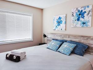 Un dormitorio con una cama con almohadas azules y una ventana en Calgary Gorgeous Single House close LRT&UC&Free Parking en Calgary