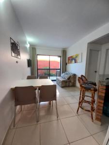 sala de estar con mesa, sillas y sofá en Apartamento Porto das Dunas, en Aquiraz