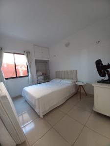 a bedroom with a bed and a television in it at Apartamento Porto das Dunas in Aquiraz