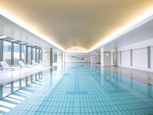 a large swimming pool with blue tiles in a building at Grand Prince Hotel Osaka Bay in Osaka