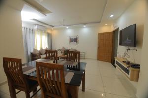 a dining room with a table and chairs and a television at Castle Brook Residential Homestay in Thiruvalla