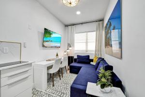 uma sala de estar com um sofá azul e uma mesa em SOBE MONARCH 2BEDROOM 2 BATH MODERN apt- WALK TO OCEAN DRIVE em Miami Beach