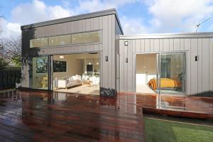 une maison avec une grande porte en verre sur une terrasse dans l'établissement The Mod Box, à Invercargill