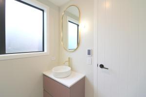 a bathroom with a sink and a mirror at The Mod Box in Invercargill