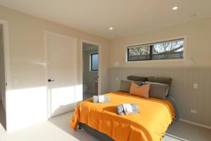 1 dormitorio con 1 cama con 2 toallas en The Mod Box en Invercargill