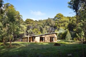 ein Haus mitten auf einem Feld mit Bäumen in der Unterkunft Gumtree Spring in Daylesford
