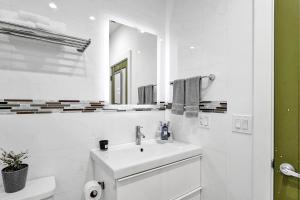 La salle de bains blanche est pourvue d'un lavabo et d'un miroir. dans l'établissement SOBE MONARCH 2BEDROOM 2 BATH MODERN apt- WALK TO OCEAN DRIVE, à Miami Beach