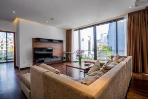 a living room with a large couch and a television at Stunning Da Nang Beach Villa in Da Nang
