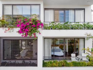 a white house with pink flowers in a window box at Stunning Da Nang Beach Villa in Da Nang