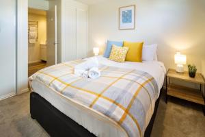 a bedroom with a large bed with towels on it at The Cozy Cocoon 1 Bed 1 Bath Apartment in Christchurch
