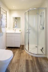 a bathroom with a shower and a toilet and a sink at The Cozy Cocoon 1 Bed 1 Bath Apartment in Christchurch +17 photos