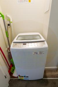 a washing machine sitting in the corner of a room at The Cozy Cocoon 1 Bed 1 Bath Apartment in Christchurch