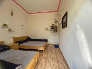 a room with two beds and a wall at MŨM HOMESTAY MỘC CHÂU in Mộc Châu