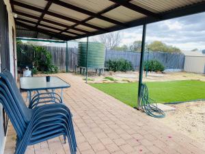 a patio with a table and chairs under a roof at The Bungalow - Wave Rock Short Stay in Hyden