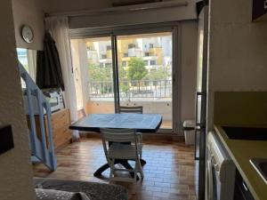 een tafel en stoelen in een keuken met een raam bij Appartement Cap d'Agde, 3 pièces, 6 personnes - FR-1-749-8 in Cap d'Agde
