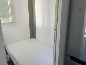 a small white room with a bed in it at Appartement Cap d'Agde, 3 pièces, 4 personnes - FR-1-749-9 in Cap d'Agde