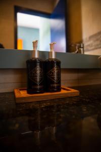 two black shampoo bottles sitting on a cutting board at Jama Campay - Homes Resort & Spa in Jama