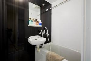 a bathroom with a white sink and a bath tub at City Oasis in Tokyo
