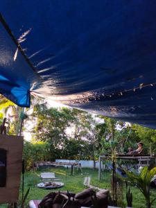 a blue tent with people sitting in a yard at Nomada Hostel in Leticia