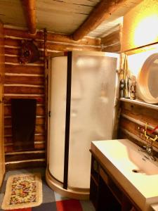 a kitchen with a refrigerator and a sink in a room at Chalet en bois rond Mauricie in Saint-Alexis-des-Monts