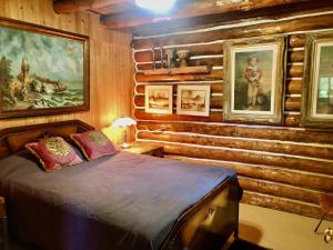 1 dormitorio con 1 cama en una cabaña de madera en Chalet en bois rond Mauricie en Saint-Alexis-des-Monts