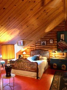 a bedroom with a bed in a log cabin at Chalet en bois rond Mauricie in Saint-Alexis-des-Monts