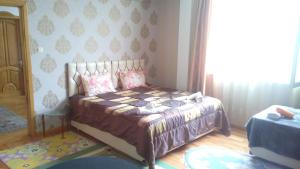 a bedroom with a bed and a large window at Dzveli Batumi in Batumi