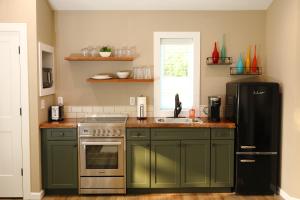 eine Küche mit grünen Schränken und einem schwarzen Kühlschrank in der Unterkunft the evergreene in Fredericktown