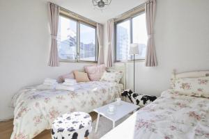 1 dormitorio pequeño con 2 camas y mesa en City Oasis en Tokio