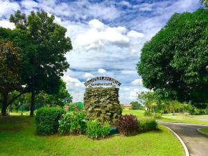 a park with a stone monument in the grass at ABE Lodge Taguig in Manila