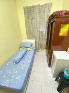 a small room with a bed and a cabinet at The Z Homestay in Jitra