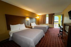 um quarto de hotel com duas camas e uma televisão em Red Carpet Inn Kinston em Kinston