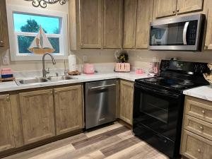 a kitchen with a stove and a sink and a microwave at Pink Flamingo House in Cocoa