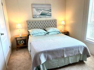 a bedroom with a bed with two night stands and two lamps at Pink Flamingo House in Cocoa