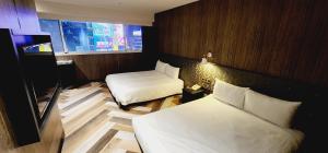una camera d'albergo con due letti e una finestra di 慶爾喜旅館西門捷運館Gugis Inn a Taipei