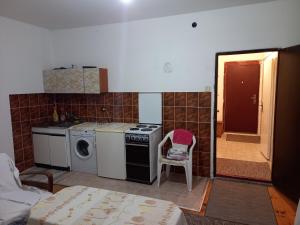 a kitchen with a stove and a washing machine at Surcin center house in Surčin