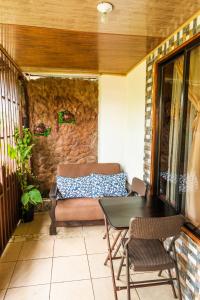 a patio with a couch and a table and chairs at Cabina Arenal Z13 in Fortuna