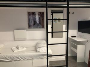 um quarto com um beliche e uma televisão em M Pods Malaga em Málaga