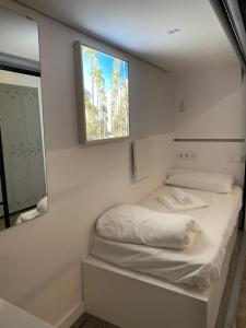 Cette petite chambre comprend un lit et une fenêtre. dans l'établissement M Pods Malaga, à Malaga