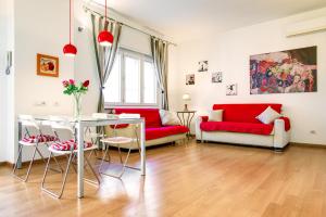 salon z czerwonymi kanapami i stołem w obiekcie Lovely apartment in Rome - Casetta Mattei w Rzymie